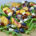 Grilled Peach Salad is the best summer side dish recipe!  The peaches and onions are grilled and served with arugula, blueberries, candied pecans, and blue cheese. 