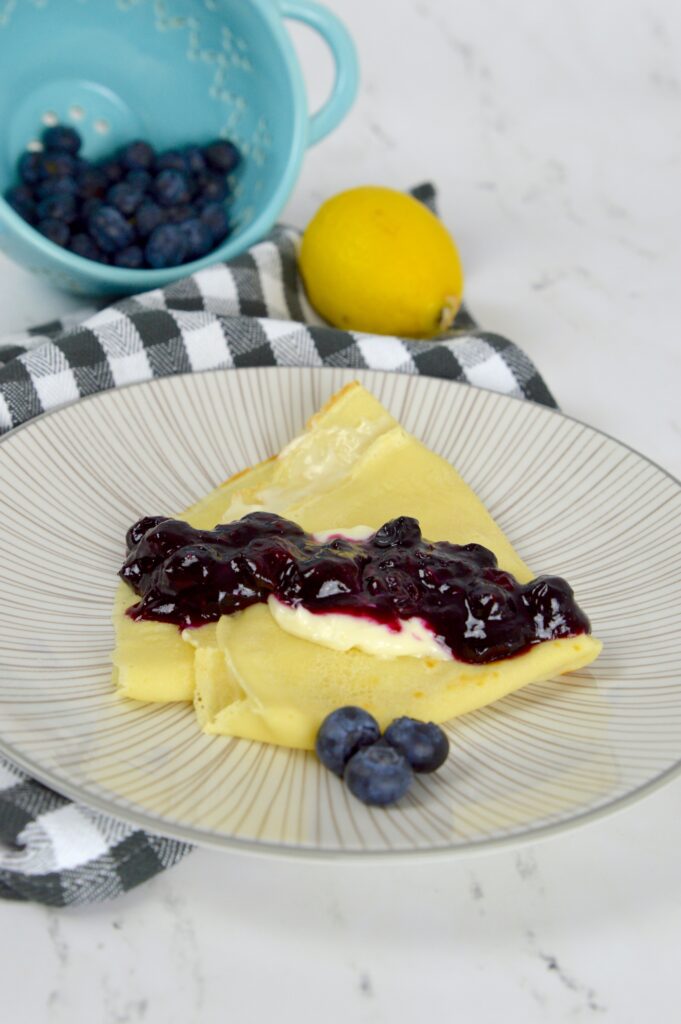 Delicious French-inspired Blueberry Cream Cheese Crepes filled with sweet cream cheese and topped with bursting blueberries.