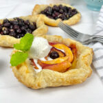 Gorgeous mini peach blueberry galettes are the perfect, fun, and simple dessert with seasonal fruit.