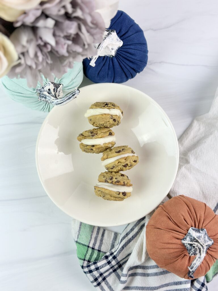 Soft and chewy pumpkin chocolate chip sandwich cookies stuffed with cream cheese frosting are a must-try this fall!